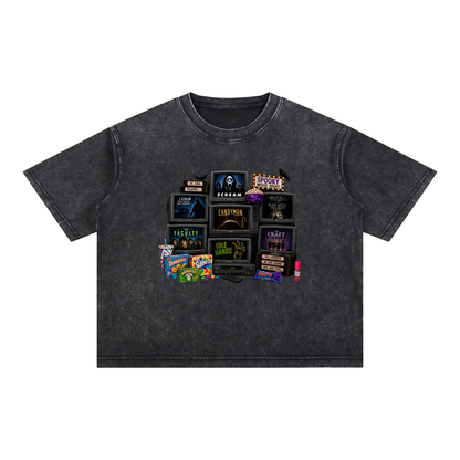 A dark gray acid-wash t-shirt featuring a collage graphic of various horror movie and TV show title cards printed on the chest, displayed flat against a solid white background.